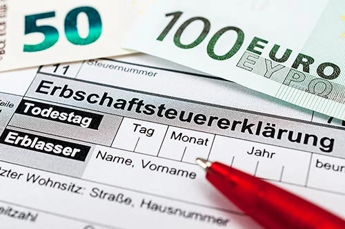 Erbschaftssteuerformular mit einem roten Stift und Euro-Banknoten darauf. - Bestattungsunternehmen in Winsen, Harburg und in der Elbmarsch.